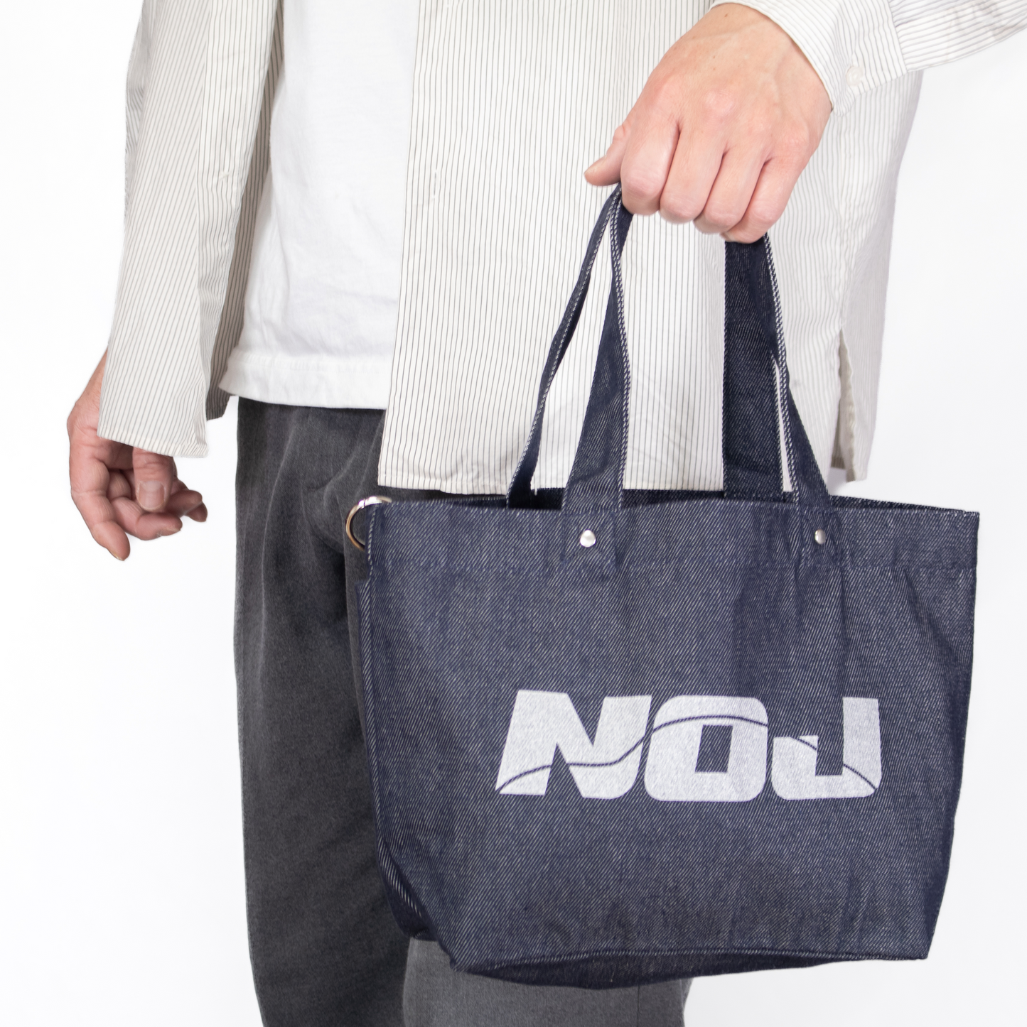 NOJデニムトートバッグを手に持った状態の使用イメージ。サイズ感が分かる画像