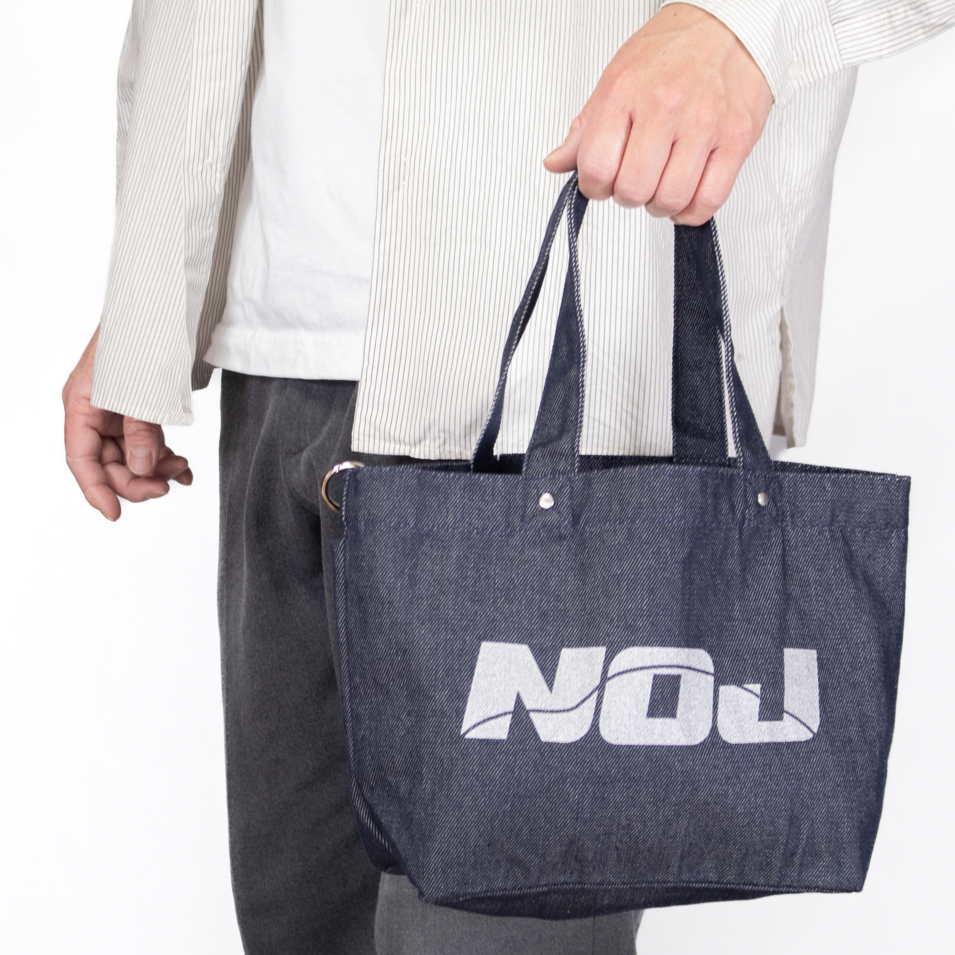 NOJデニムトートバッグを手に持った状態の使用イメージ。サイズ感が分かる画像