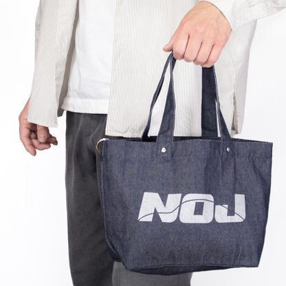 NOJデニムトートバッグを手に持った状態の使用イメージ。サイズ感が分かる画像